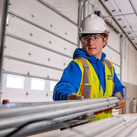 worker smiling and holding materials